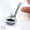 volume fan dipping in disposable glue cup containing eyelash extension glue