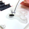 Disposable Lash Glue Tray in use on Lash Layout Base with tweezers pinching volume fan
