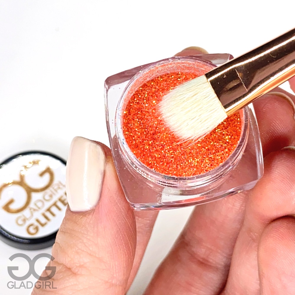 Flat eyeshadow brush picking up glitter close up